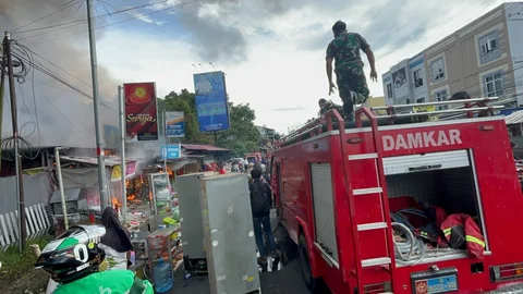 Prajurit TNI Angkatan Laut dari Kodaeral VIII bersama petugas dan warga memadamkan kebakaran di permukiman Kelurahan Kairagi Weru, Kota Manado, Selasa (28/4/2026).