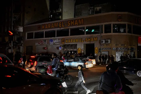 Orang-orang berjalan melewati toko-toko yang tutup lebih awal karena pemberlakuan jam malam yang diperintahkan pemerintah untuk mengurangi biaya energi di pusat kota Kairo,Kamis (02/04/2026) malam.