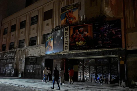 Orang-orang berjalan melewati toko-toko yang tutup lebih awal karena pemberlakuan jam malam yang diperintahkan pemerintah untuk mengurangi biaya energi di pusat kota Kairo,Kamis (02/04/2026) malam.