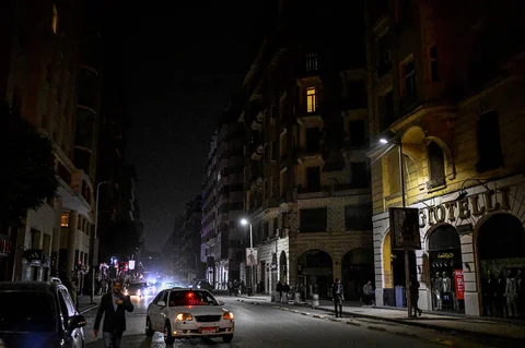 Orang-orang berjalan melewati toko-toko yang tutup lebih awal karena pemberlakuan jam malam yang diperintahkan pemerintah untuk mengurangi biaya energi di pusat kota Kairo,Kamis (02/04/2026) malam.