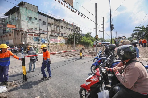 Pengendara bermotor menunggu kereta lewat pada palang pintu manual di perlintasan sebidang rel kereta api di Jalan Ampera, Bekasi, Jawa Barat, Kamis (30/04/2026).