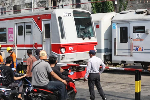 Pengendara bermotor menunggu kereta lewat pada palang pintu manual di perlintasan sebidang rel kereta api di Jalan Ampera, Bekasi, Jawa Barat, Kamis (30/04/2026).