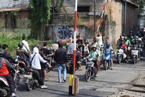 Warga membuaka palang pintu manual di perlintasan sebidang rel kereta api di Jalan Ampera, Bekasi, Jawa Barat, Kamis (30/04/2026).