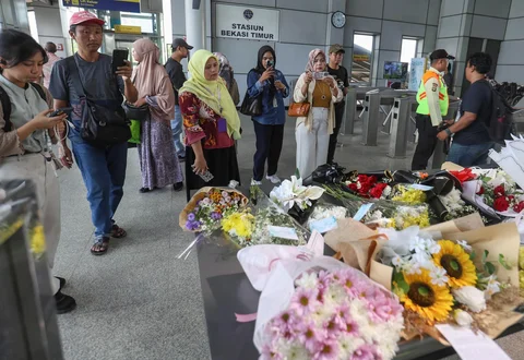 Warga melihat  karangan bunga di dekat pintu masuk peron di  Stasiun Bekasi Timur, Duren Jaya, Kota Bekasi, Kamis (30/04/2026).