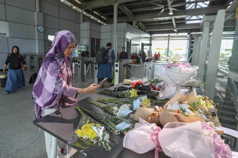 Warga memotret karangan bunga di dekat pintu masuk peron di  Stasiun Bekasi Timur, Duren Jaya, Kota Bekasi, Kamis (30/04/2026).