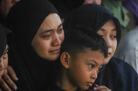 Isteri dan anak mendiang Mayor Infanteri (Anm) Zulmi Aditya Iskandar menangis saat pemakaman di Taman Makam Pahlawan (TMP) Cikutra, Bandung, Jawa Barat, Minggu (5/4/2026).