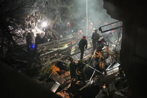 Pasukan keamanan Israel dan tim penyelamat bekerja di tengah reruntuhan bangunan tempat tinggal yang dihantam rudal Iran di Haifa, Israel, Minggu (05/04/2026).