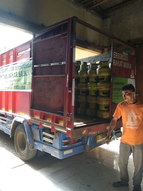 Salah seorang pegawai agen gas LPG 3 kg tengah menaikan gas melon ke salah satu mobil angkutan gas bersubisi di Garut, Jawa Barat. (Liputan6.com/Jayadi Supriadin)