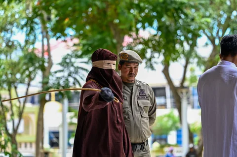 Algojo mengeksekusi cambuk terpidana pelanggar peraturan daerah (qanun) tentang hukum syariat Islam di Panggung Taman Bustanussalatin, Banda Aceh, Aceh, Selasa (07/04/2026).