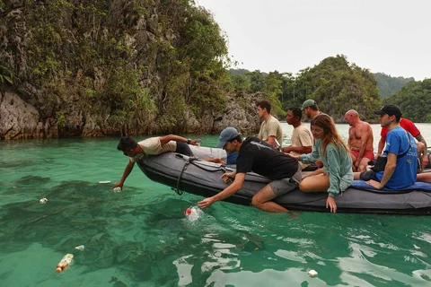Para wisatawan mengumpulkan sampah plastik dari laut di Misool, Raja Ampat, Indonesia, Senin (02/03/2026).