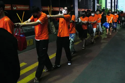 Personel kepolisian menggiring sejumlah tersangka kasus perjudian daring di Perkantoran Hayam Wuruk Plaza Tower, Jakarta, Minggu (10/5/2026).