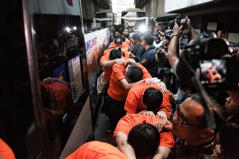 Personel kepolisian menggiring sejumlah tersangka kasus perjudian daring di Perkantoran Hayam Wuruk Plaza Tower, Jakarta, Minggu (10/5/2026).