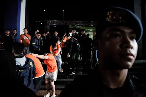Personel kepolisian menggiring sejumlah tersangka kasus perjudian daring di Perkantoran Hayam Wuruk Plaza Tower, Jakarta, Minggu (10/5/2026).