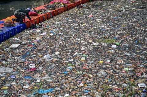 Aktivis dari ECOTON (Pengamatan Ekologi dan Konservasi Lahan Basah) dan pekerja dari Dinas Lingkungan Hidup pemerintah kota membersihkan sampah dari Sungai Kali Tebu di Surabaya, Provinsi Jawa Timur, Indonesia, Senin (11/05/2026).