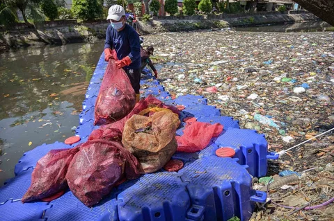 Aktivis dari ECOTON (Pengamatan Ekologi dan Konservasi Lahan Basah) dan pekerja dari Dinas Lingkungan Hidup pemerintah kota membersihkan sampah dari Sungai Kali Tebu di Surabaya, Provinsi Jawa Timur, Indonesia, Senin (11/05/2026).
