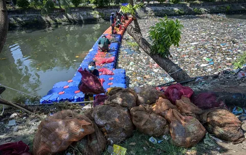 Aktivis dari ECOTON (Pengamatan Ekologi dan Konservasi Lahan Basah) dan pekerja dari Dinas Lingkungan Hidup pemerintah kota membersihkan sampah dari Sungai Kali Tebu di Surabaya, Provinsi Jawa Timur, Indonesia, Senin (11/05/2026).