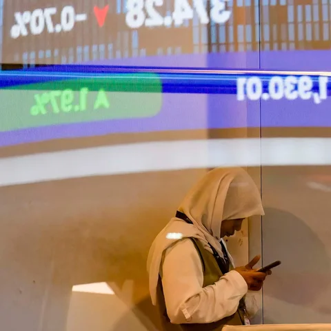 Seorang wanita terlihat di balik kaca yang memantulkan monitor yang menampilkan Indeks Komposit Indonesia (IHSG, di gedung Bursa Efek Indonesia di Jakarta Rabu (13/05/2026).