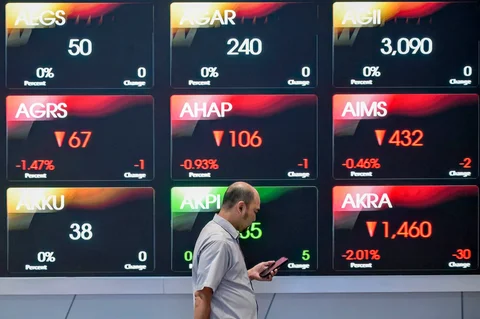 Seorang pria berjalan melewati  layar yang menampilkan Indeks Harga Saham Gabungan (IHSG), yang anjlok di gedung Bursa Efek Indonesia di Jakarta, Rabu (13/05/2026).