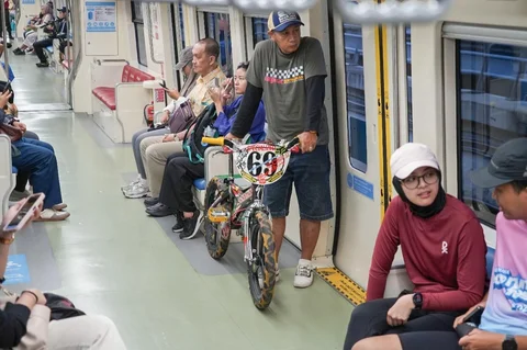 Penumpang berdiri sambil membawa sepeda di dalam gerbong kereta LRT saat melintas di kawasan Dukuh Atas, Jakarta, Rabu (13/05/2026