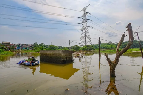 Warga membwa rumput dengan perahu karet melewati rumah warga yang kosong akibat tergenang Kali Pesanggrahan yang alirannya menyempit karena longsoran TPA Cipayung di kawasan Cipayung, Depok, Kamis (14/05/2026).