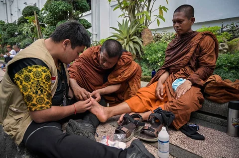 Paramedis memeriksa kaki  biksu Buddha  yang  berjalan kaki mengikuti Pawai Perdamaian 2026 di Surabaya, Jumat (15/05/2026).