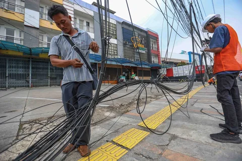 Petugas memotong kabel utilitas (Wifi ) di jalan Kartini Depok, Jawa Barat, Jumat (15/5/2026).