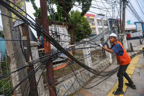Petugas memotong kabel utilitas (Wifi) di Jalan Kartini Depok, Jawa Barat, Jumat (15/5/2026).