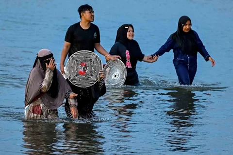 Warga berendam sambil mencari kerang di muara pelabuhan kawasan Lampulo, Banda Aceh, Jumat (15/05/2026).