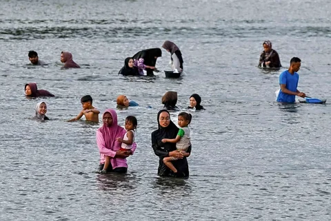 Warga berendam sambil mencari kerang di muara pelabuhan kawasan Lampulo, Banda Aceh, Jumat (15/05/2026).