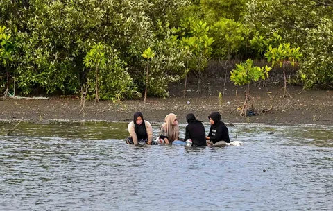 Warga berendam sambil mencari kerang di muara pelabuhan kawasan Lampulo, Banda Aceh, Jumat (15/05/2026).