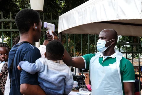 Seorang petugas kesehatan menggunakan termometer untuk memeriksa suhu tubuh orang-orang di depan Rumah Sakit Muslim Kibuli di Kampala, Uganda, Sabtu, (16/05/2026).