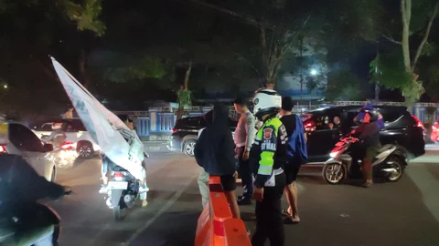 Polisi dan Bobotoh bertegur sapa di Jalan Ariajipang, Kota Bandung, pada Minggu (17/5).