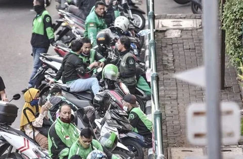 Pengemudi ojek online (ojol) memenuhi bahu jalan saat menunggu penumpang di kawasan Cililitan, Jakarta, Rabu (16/9/2020). Minimnya pengawasan membuat masih banyak pengemudi ojol yang berkerum