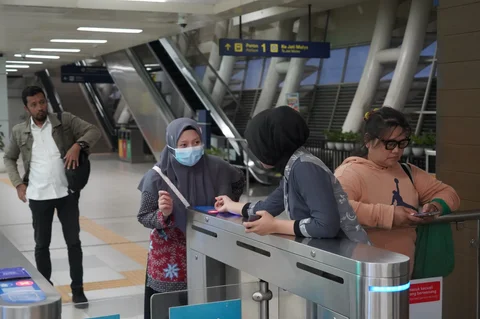 Calon penumpang melakukan tap-in menuju gerbong LRT di Stasiun  Bekasi Barat, Jawa Barat, Senin (18/05/2026).
