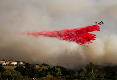 Sebuah pesawat tanker menjatuhkan bahan pemadam api ke lokasi kebakaran hutan  di Simi Valley, California, Senin (18/05/2026) waktu setempat.