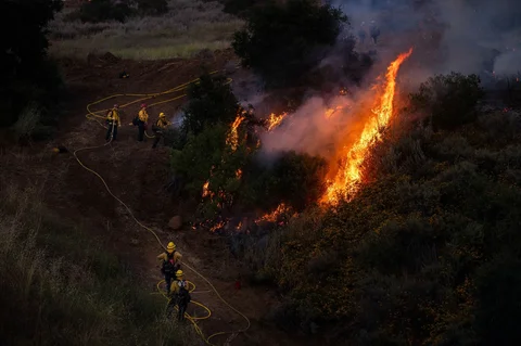 Petugas pemadam kebakaram memadamkan api pada  lokasi kebakaran hutan  di Simi Valley, California, Senin (18/05/2026) waktu setempat.