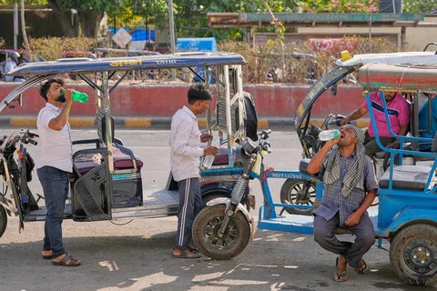 Pengemudi becak listrik minum air pada siang hari yang panas di New Delhi, India, Rabu (20/05/2026).<br />AP Photo/Manish Swarup