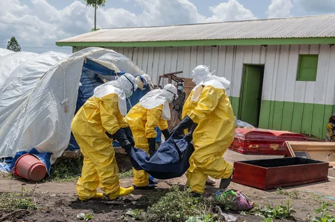 Para pekerja Palang Merah membawa jenazah seseorang yang meninggal karena Ebola ke dalam peti mati di sebuah pusat kesehatan di Rwampara, Kongo, Rabu (20/05/2026).