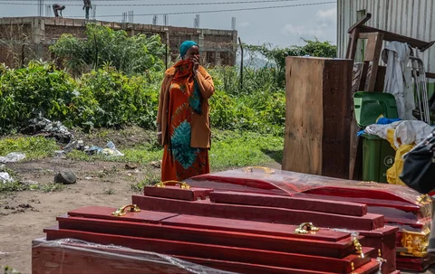 Anggota keluarga dari orang-orang yang meninggal karena Ebola berdiri di samping peti mati di sebuah pusat kesehatan di Rwampara, Kongo, Rabu (20/05/2026).