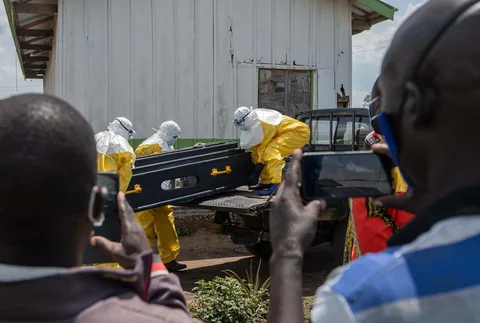 Para pekerja Palang Merah membawa peti jenazah seseorang yang meninggal karena Ebola ke bak belakang truk pikap di sebuah pusat kesehatan di Rwampara, Kongo, Rabu (20/05/2026).