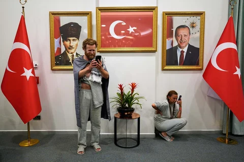 Para aktivis dari Global Sumud Flotilla  menggunakan handphone berkabar dengan keluarganya  saat tiba di Bandara Istanbul, Istanbul, Turki, Kamis (21/05/2026).