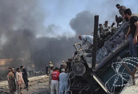 Seorang sukarelawan membantu korban luka keluar dari gerbong kereta yang terbalik  akibat ledakan bom  di Quetta, Pakistan, Minggu (24/05/2026).