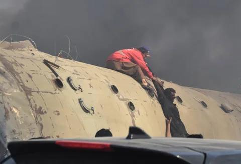 Seorang sukarelawan membantu korban luka keluar dari gerbong kereta yang terbalik  akibat ledakan bom  di Quetta, Pakistan, Minggu (24/05/2026).