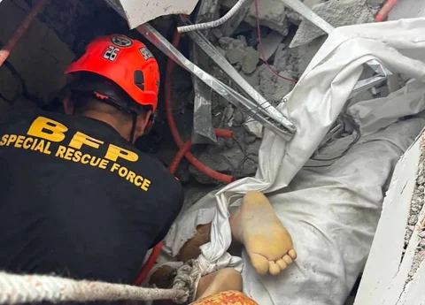 Tim penyelamat mengevakuasi jenasah yang terjebak bangunan yang runtuh di kota Angeles, provinsi Pampanga, utara Manila, Minggu (24/05/2026).