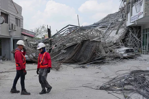 Pekerja berdiri dekat bangunan yang runtuh di kota Angeles, provinsi Pampanga, utara Manila, Senin (25/05/2026).