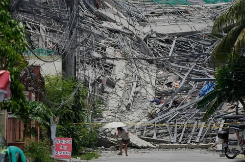 Warga berjalan dekat bangunan yang runtuh di kota Angeles, provinsi Pampanga, utara Manila, Senin (25/05/2026).
