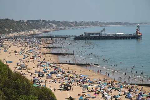 Para pengunjung berjemur menikmati sinar matahari saat gelombang panas menyebar ke sebagian wilayah tenggara Inggris dan London di pantai Bournemouth, Inggri, Senin (26/05/2026).