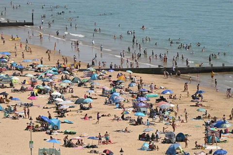 Para pengunjung berjemur menikmati sinar matahari saat gelombang panas menyebar ke sebagian wilayah tenggara Inggris dan London di pantai Bournemouth, Inggri, Senin (26/05/2026).