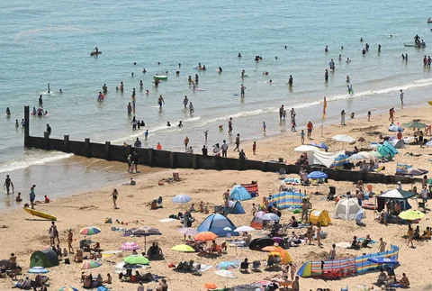 Para pengunjung berjemur menikmati sinar matahari saat gelombang panas menyebar ke sebagian wilayah tenggara Inggris dan London di pantai Bournemouth, Inggri, Senin (26/05/2026).
