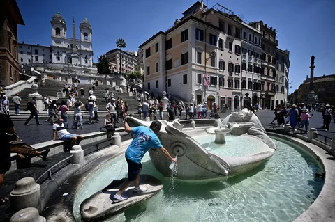 Seorang pria mengambil air pada taman  saat gelombang panas awal musim di Roma, Italia,  Seelasa (26/05/2026).